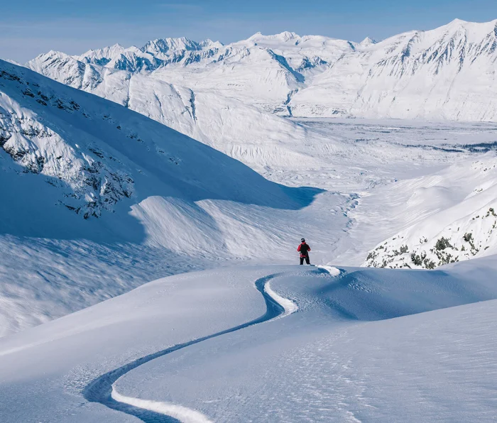 A skier dropping into a steep chute in the Chugach Mountains, Alaska