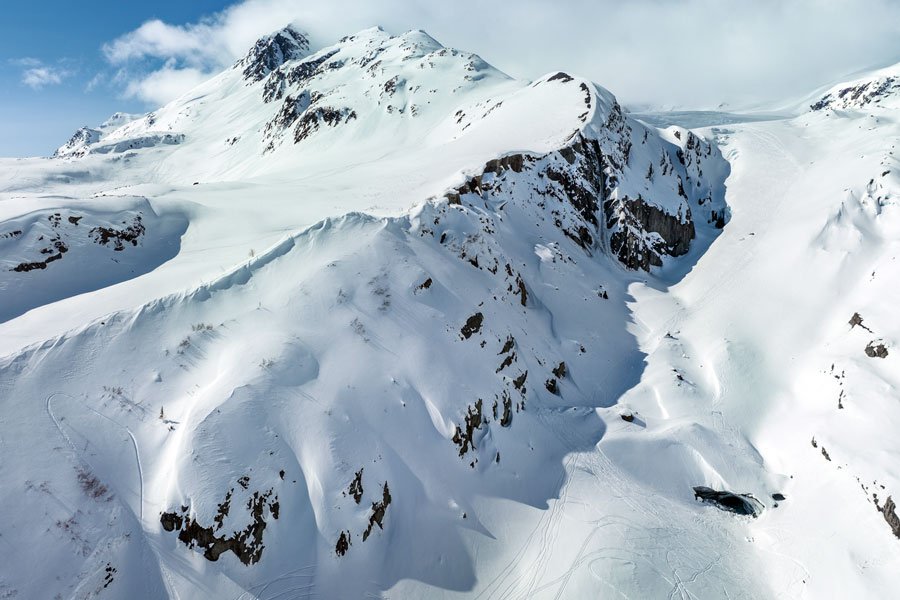 A skier making turns down a steep fluted wall in the Chugach Mountains