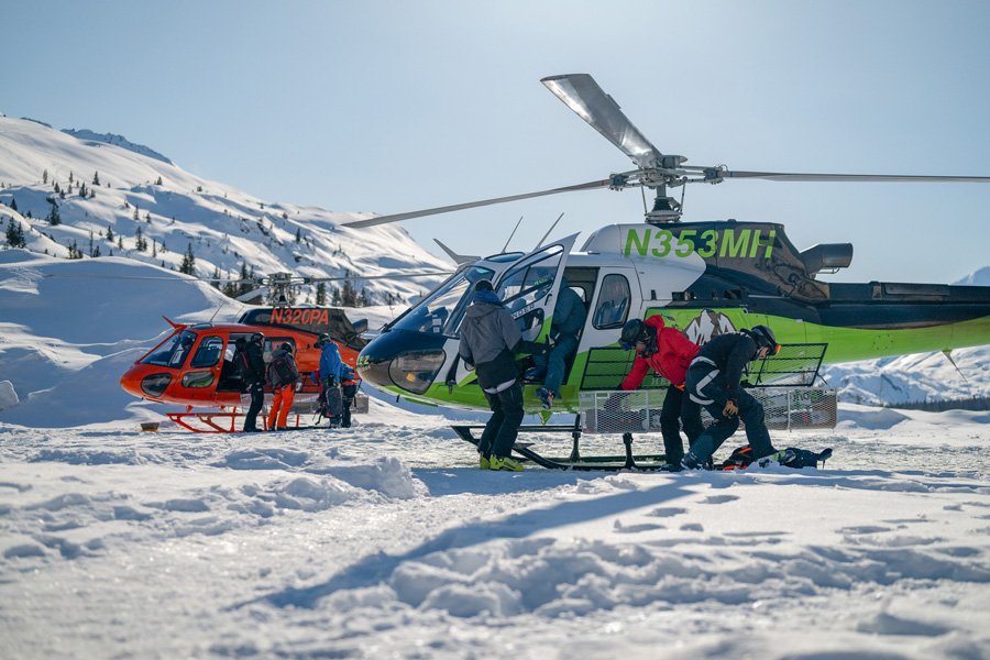 A helicopter dropping skiers on an untouched ridge in the Chugach Mountains